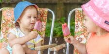 10 super easy popsicle recipes to help you beat the dog days of summer two kids in bucket hats eating popsicles- popsicle recipe