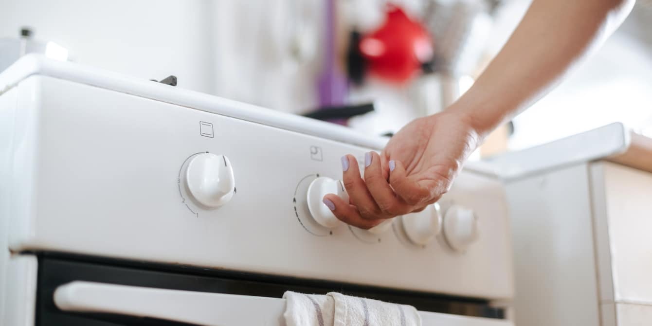 The hidden health risks of gas stoves, explained by an expert hand turning on a gas stove