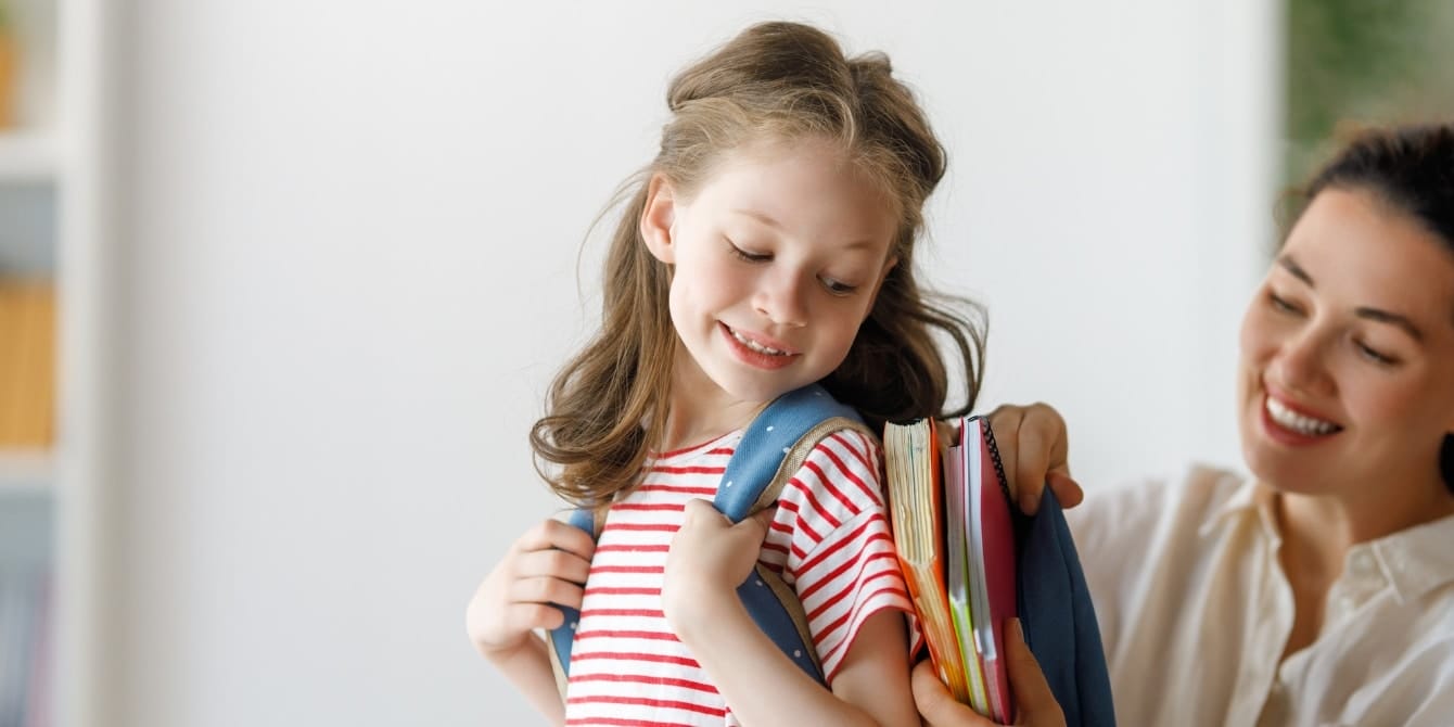 5 simple ways to head back to school sustainably mom putting books in backpack on little girl