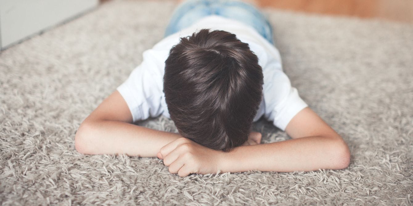Study shows 2 in 5 kids experience verbal abuse by adults—here’s how parents can do better Sad child on floor