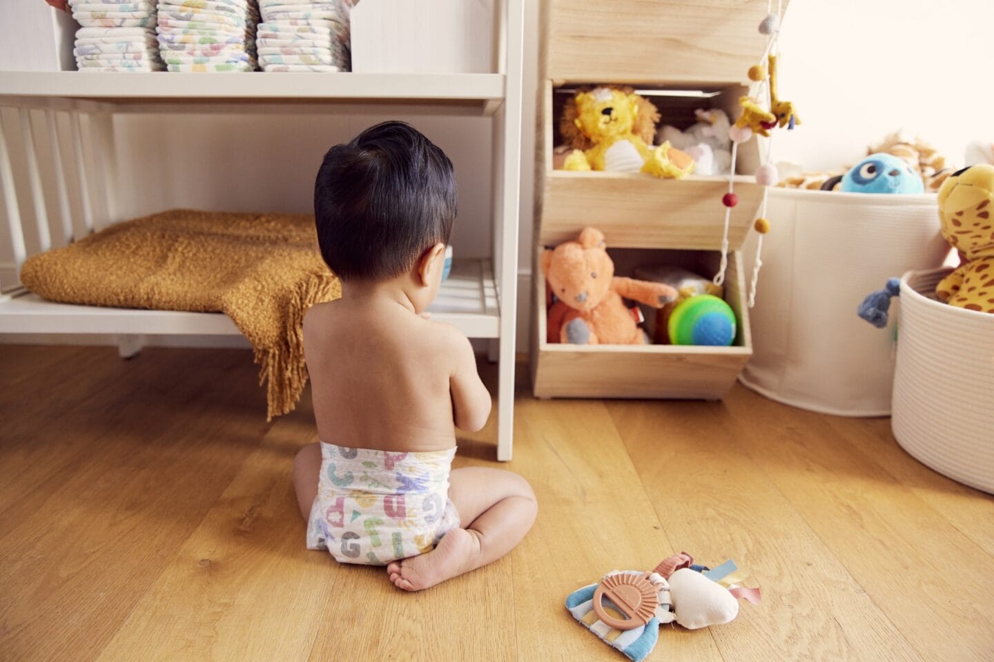 Nearly 1 in 2 families struggle to afford diapers baby playing by changing station in diaper - end diaper need act