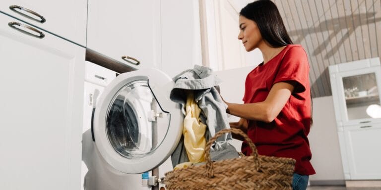 TikToker shares wild and effective alternative to fabric softener Woman loading laundry into washing machine.