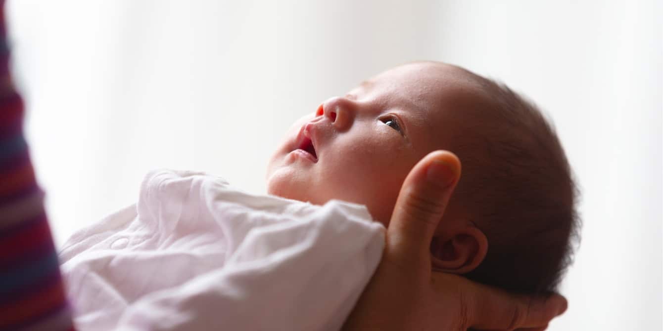 How you can support your baby’s mental health close up of parent holding newborn baby - infant mental health
