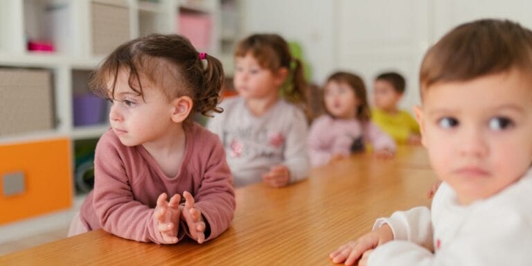 5 questions I’m asking daycare centers as an antiracist mama group of children at table in daycare - questions to ask a daycare provider