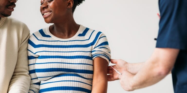 Health officials urge pregnant women to get vaccinated against flu, Covid and RSV pregnant woman getting flu shot from doctor - flu covid rsv