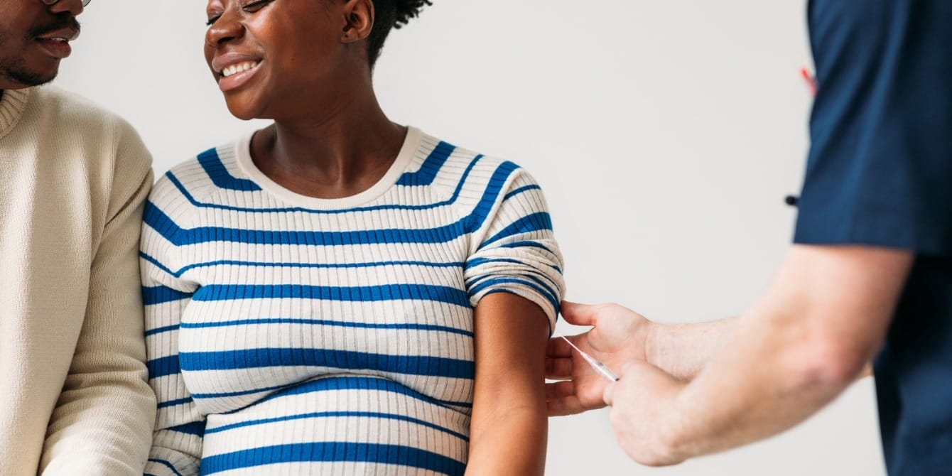 Health officials urge pregnant women to get vaccinated against flu, Covid and RSV pregnant woman getting flu shot from doctor - flu covid rsv