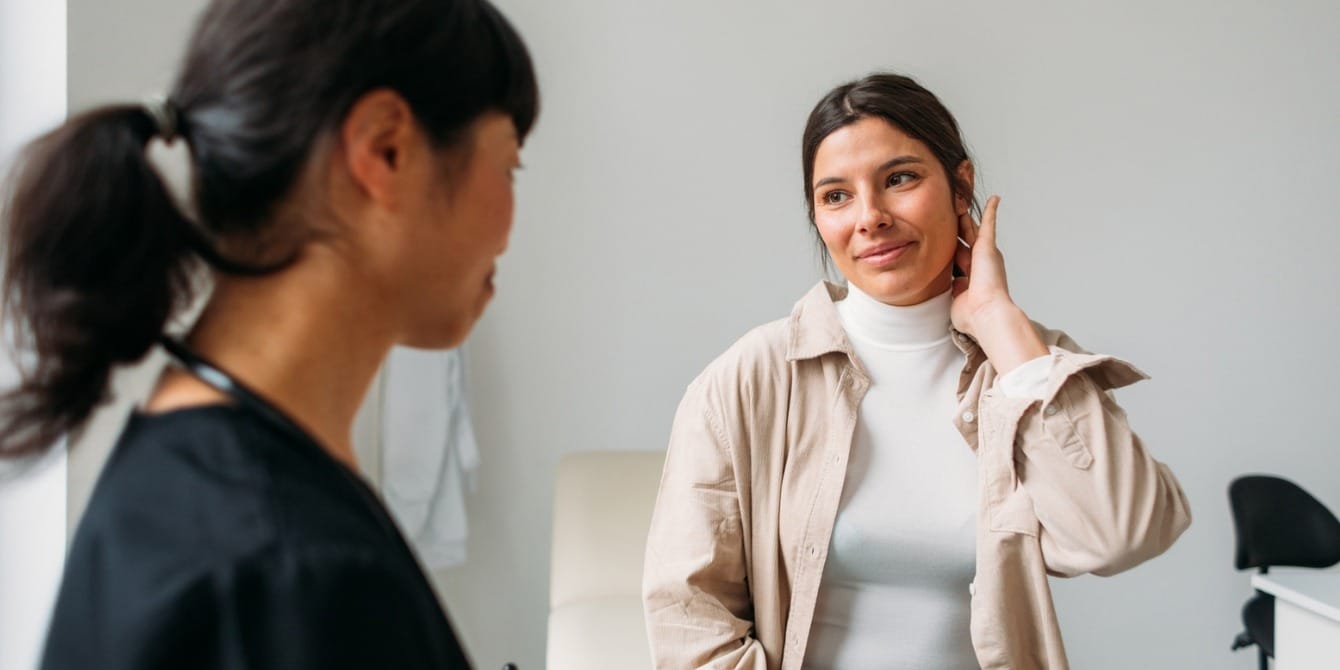 Infertility care is healthcare—and should be covered by insurance young woman at checkup with her doctor - infertility care is healthcare