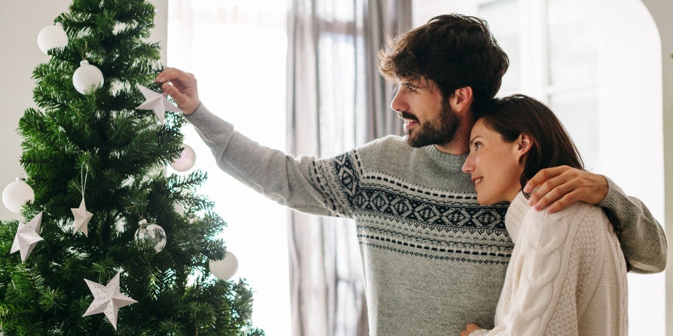 A Christmas surprise: Embracing the unexpected husband and wife by a christmas tree - 7 months postpartum and pregnant