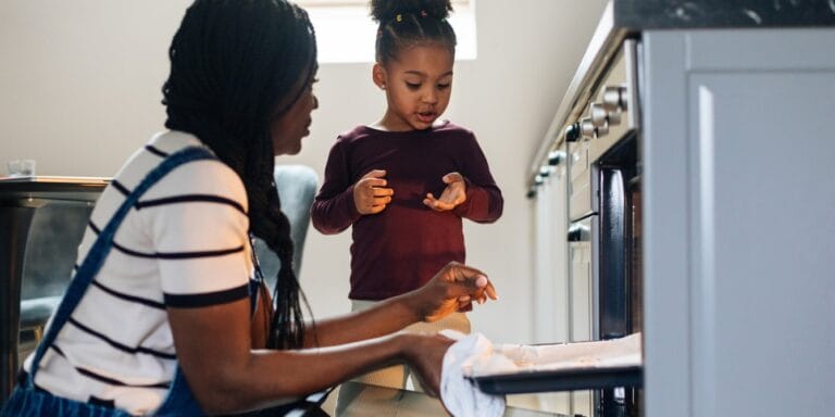 7 kid-friendly ways to use canned pumpkin (beyond pumpkin pie!) mom and daughter taking baking sheet from oven canned pumpkin recipes
