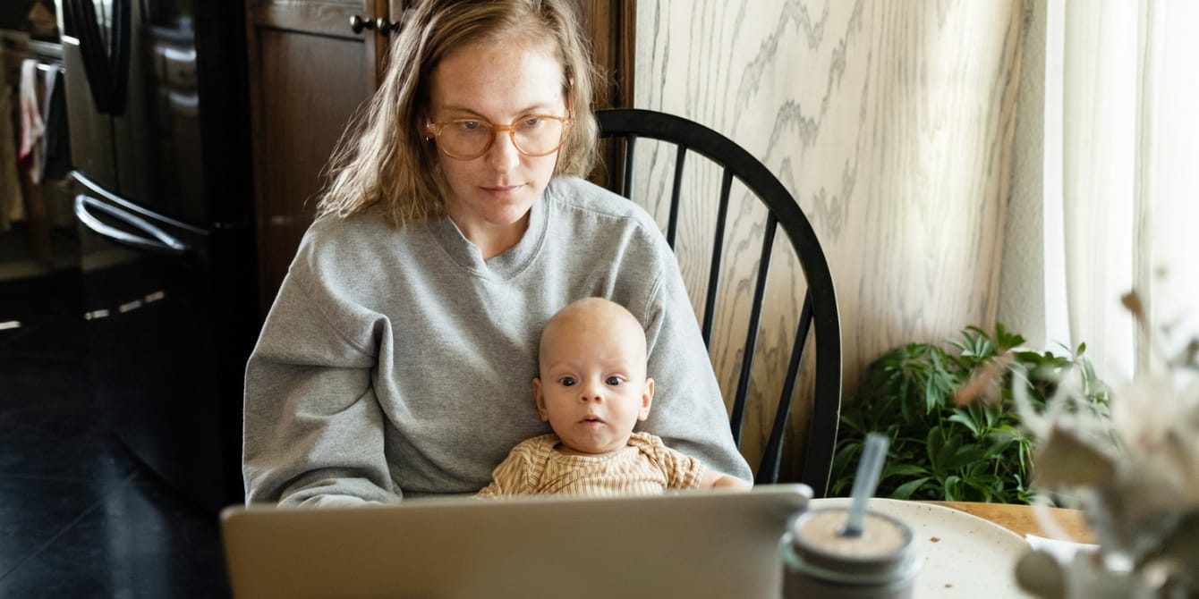 Parents are turning to ChatGPT for medical advice. But is it safe? mom using laptop with baby on her lap - chatgpt for medical advice