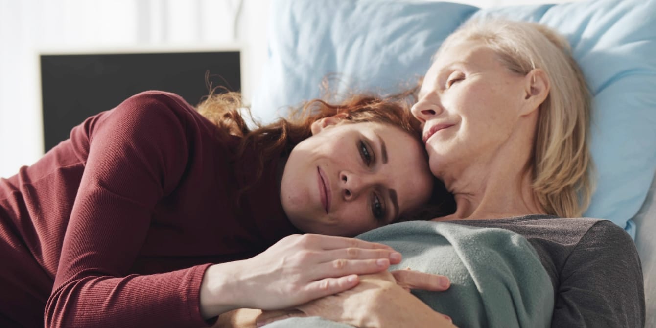 I’m the ‘alpha daughter’—and maybe you are, too? woman lying on hospital bed with aging mother