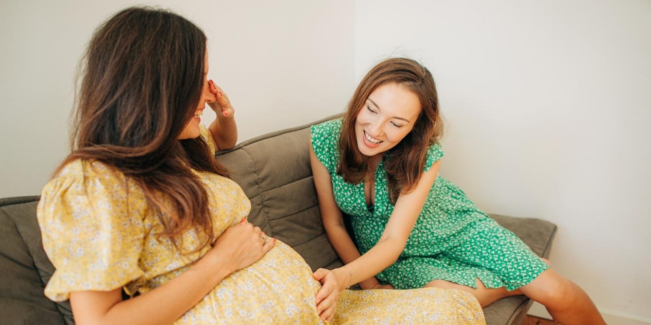 Please don’t comment on my bump size, period woman touching the pregnant belly of her friend - pregnancy bump size