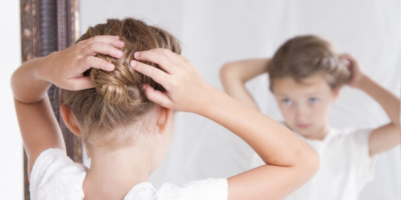 5 ways to teach your 8-year-old about body neutrality young girl doing her hair in the mirror - body neutrality