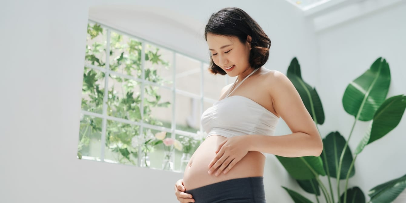 Does the pregnancy glow really exist? happy pregnant woman touching her belly - pregnancy glow