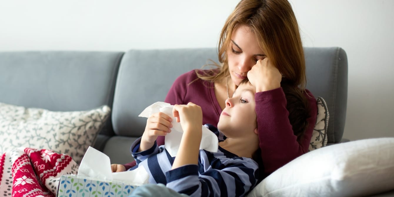 Why having two kids makes you 8 times more likely to get sick sick mom and son on couch families with kids experience more sickness