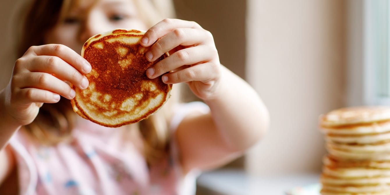 The best foods to feed your sick toddler, according to a pediatric dietitian preschool girl holding pancake -foods to feed your sick toddler
