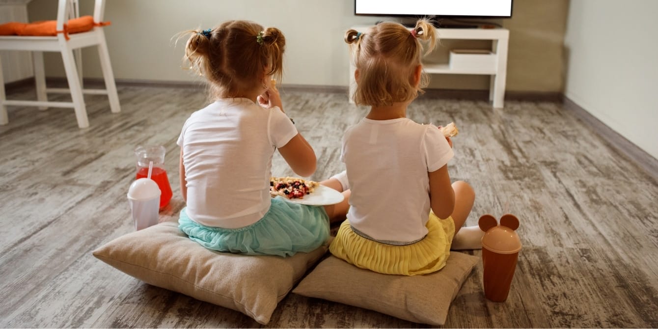 Former teacher shares her ‘secret weapon’ on reducing screen time two girls with snacks sitting in front of tv reduce screen time tips