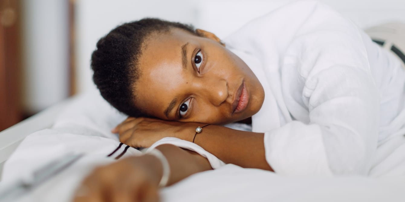 Having an autoimmune disease could increase your risk of PPD by 30%, study finds woman lying on a bed autoimmune disease and postpartum depression