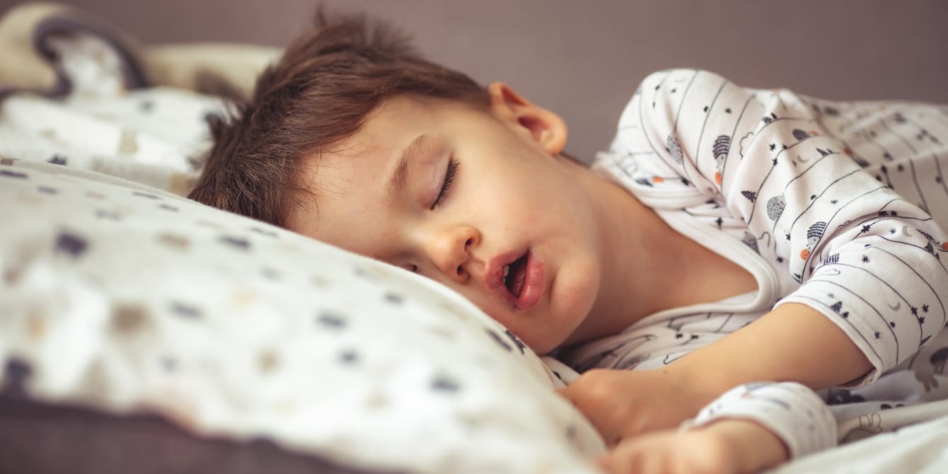 Does my child have sleep apnea? child in bed sleeping with mouth open pediatric sleep apnea