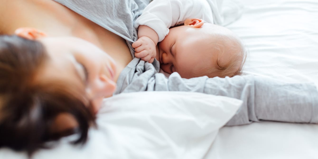 Postpartum rest is important—here’s why you should plan yours mom in bed nursing baby - postpartum rest