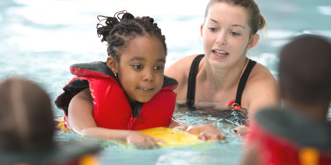 New parents in New York will receive drowning prevention training before leaving the hospital Woman giving swimming lessons to young girl