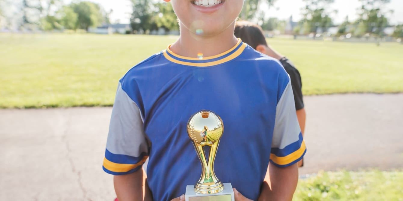 A parent’s guide to nurturing high achievers child holding trophy- high achiever's guide