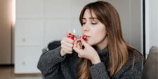 High on motherhood: The rise of the ‘Cannamoms’ woman smoking marijuana from pipe at home