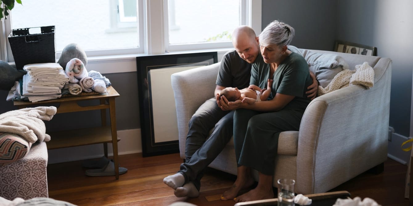 This brilliant piece of parenting advice helped me avoid marital spats in early motherhood new parents holding baby marital advice