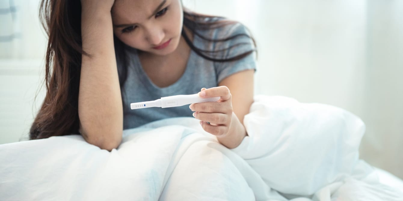 Struggling to conceive after having your first baby? There’s a name for that, and it’s more common than you think sad woman holding pregnancy test - how common is secondary infertility