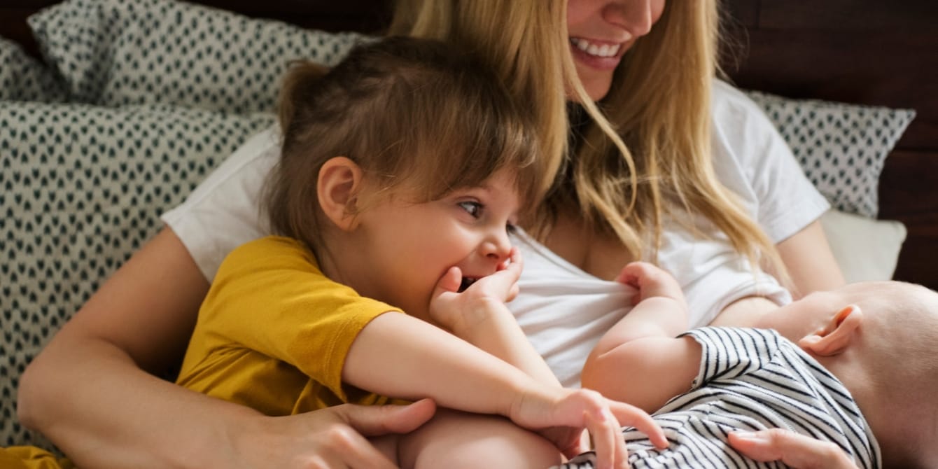 Breaking bigger: The messy business of expanding your heart mom nursing a baby holding a toddler- breaking bigger