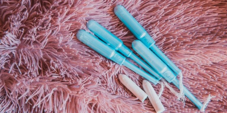 Are girls’ periods starting earlier? Study says yes blue tampon applicators and tampons on pink shag rug