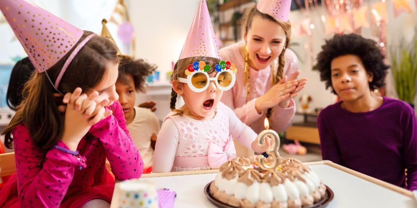 More and more parents are opting for ‘no gift’ birthday parties—here’s why Children gathered around a cake at a birthday party