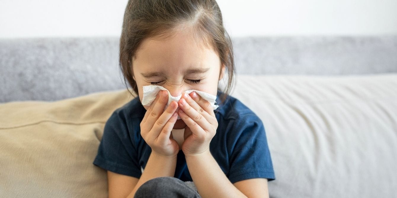 American Academy of Pediatrics releases updated guidance ahead of flu season Girl sneezing into tissue