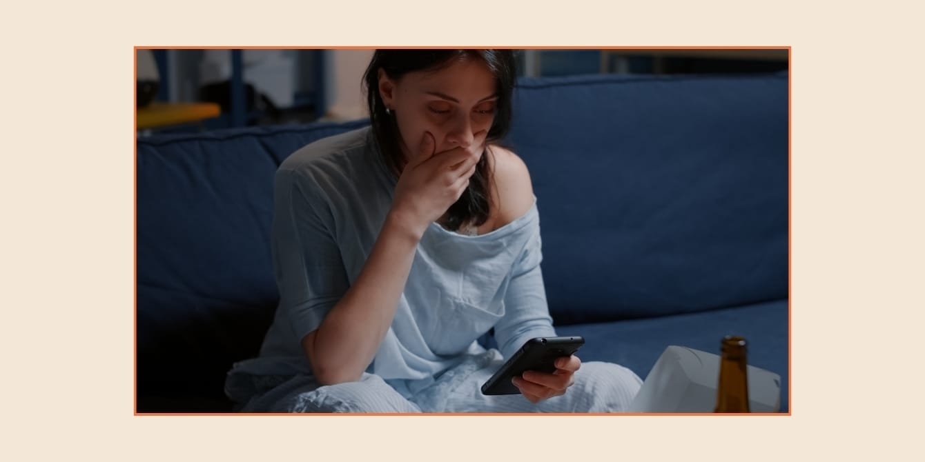 Teen vacation or invoice surprise? Why we need to talk about family trip etiquette Reddit AITA: An image of a woman looking at her phone with worry
