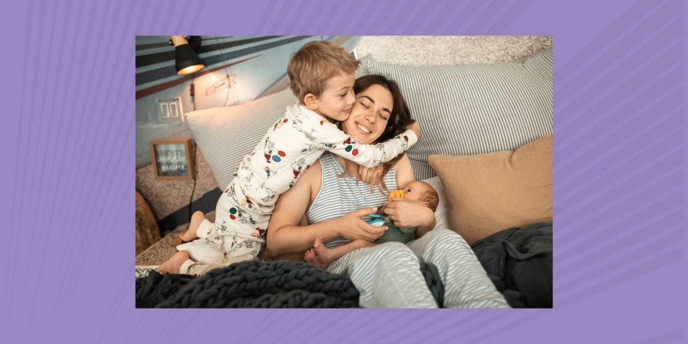 Mom holding baby while her toddler gives her a hug