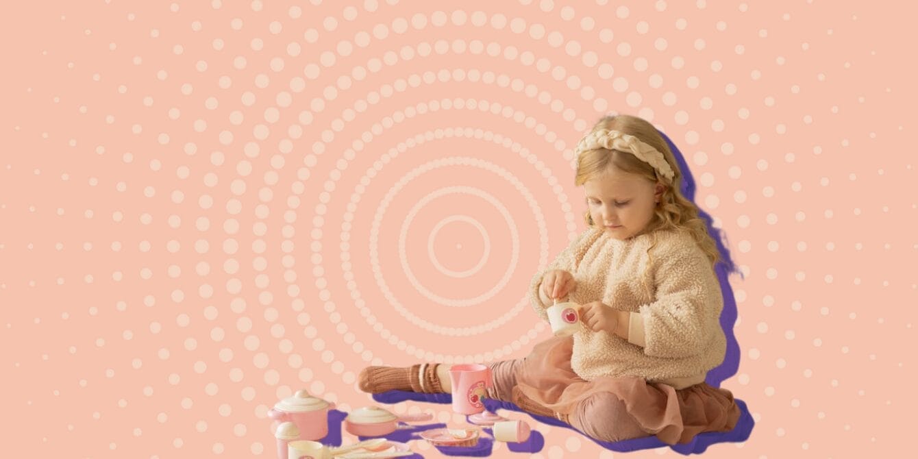 Toddler in potty-training stage sitting on floor playing with toy cookware pretending to make food