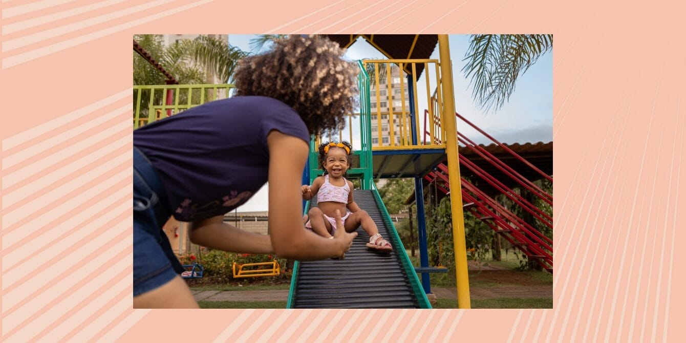 Mom waiting for baby who is sliding down the slide at the park
